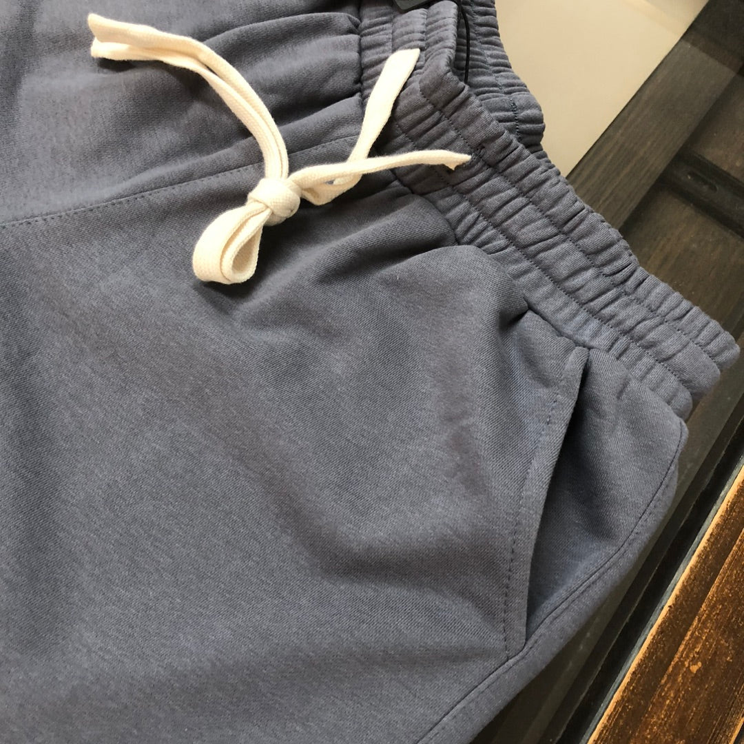 Gray drawstring shorts close-up: elastic waist and white drawcord
