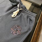 Dark gray Stone Island shorts with elastic waistband, yellow drawstring, and logo patch