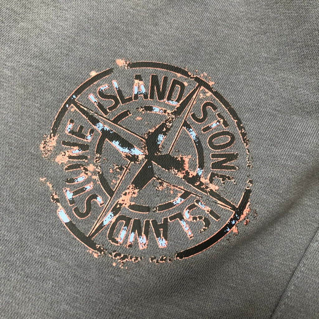 Close-up of Stone Island circular logo graphic patch on dark gray fabric