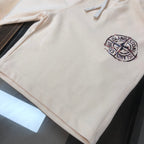 Cream Stone Island shorts with small chest-style logo and drawstring ties