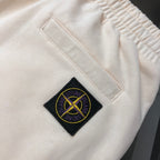 Cream Stone Island logo patch on shorts fabric near an inner seam