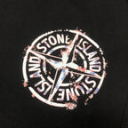Stone Island circular logo patch on black shorts, featuring multicolor detailing