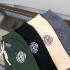 Stone Island shorts in dark green, black, and cream with circular logo patch