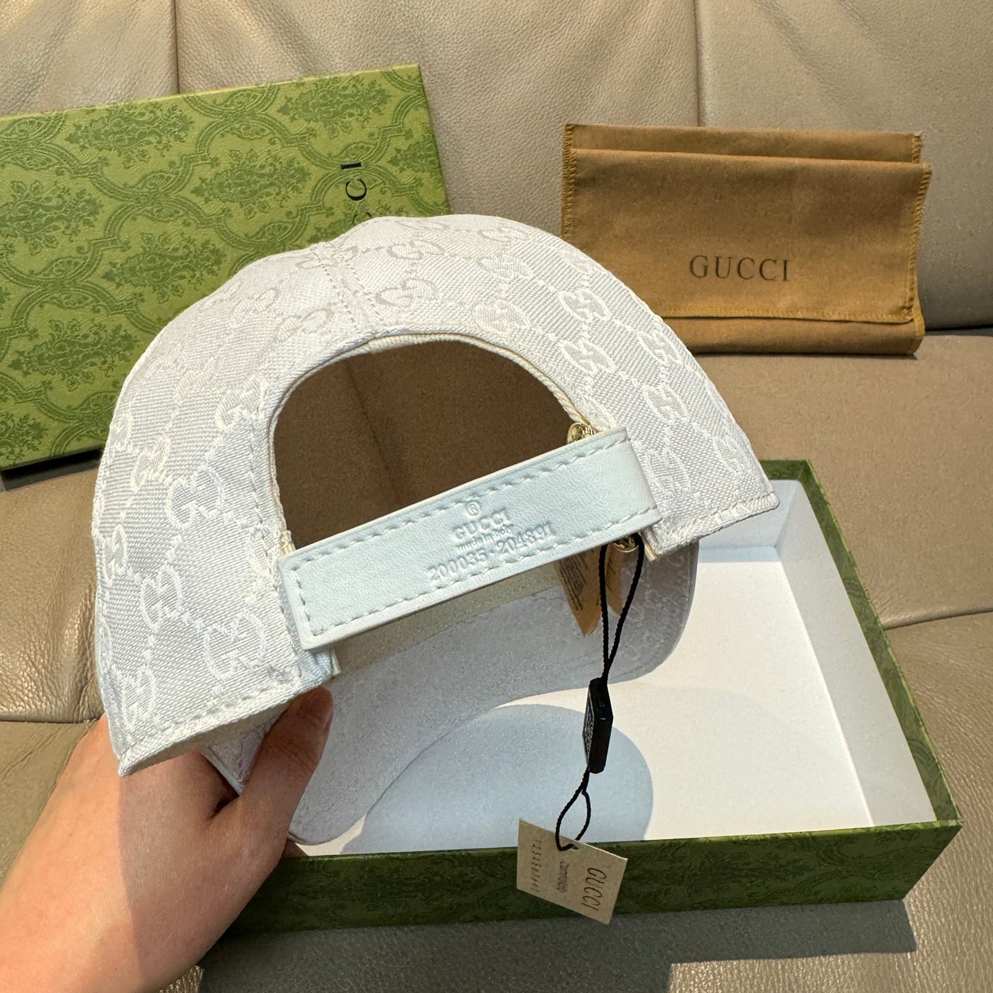 White Gucci cap back view with adjustable strap and GG monogram fabric
