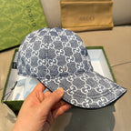 Gucci cap in dark blue with repeating GG monogram pattern, curved brim close-up in hand