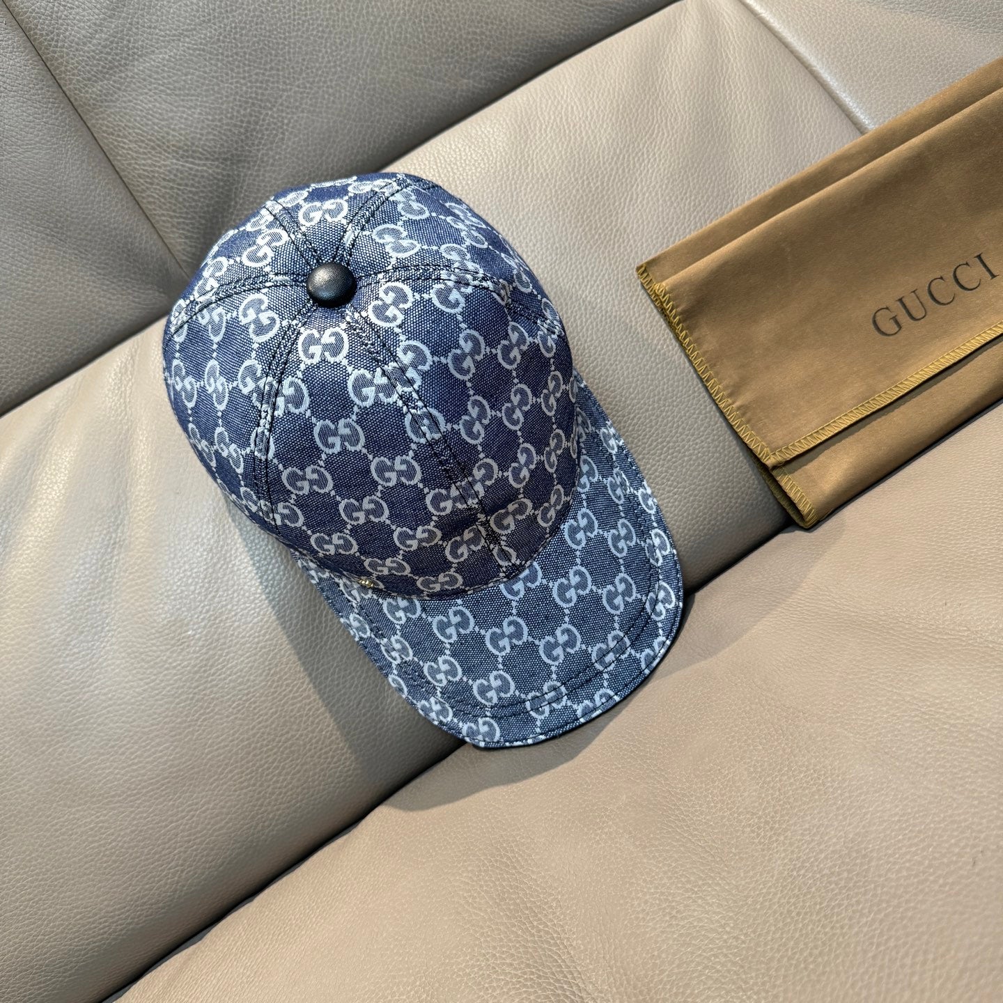 Gucci cap in dark blue with repeating GG monogram pattern, side panel and round top button