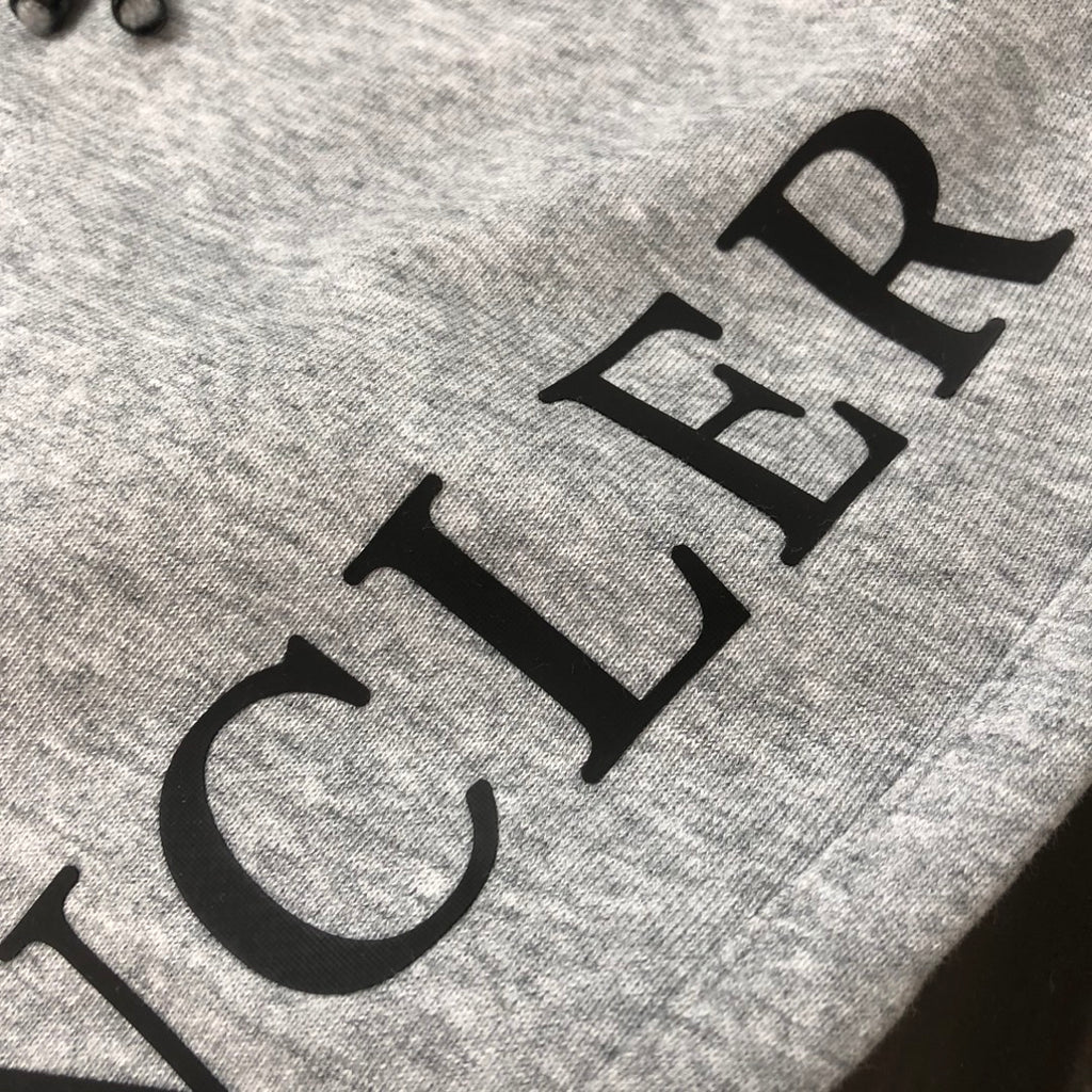 Stone Island shorts, light gray with large black logo text on the leg