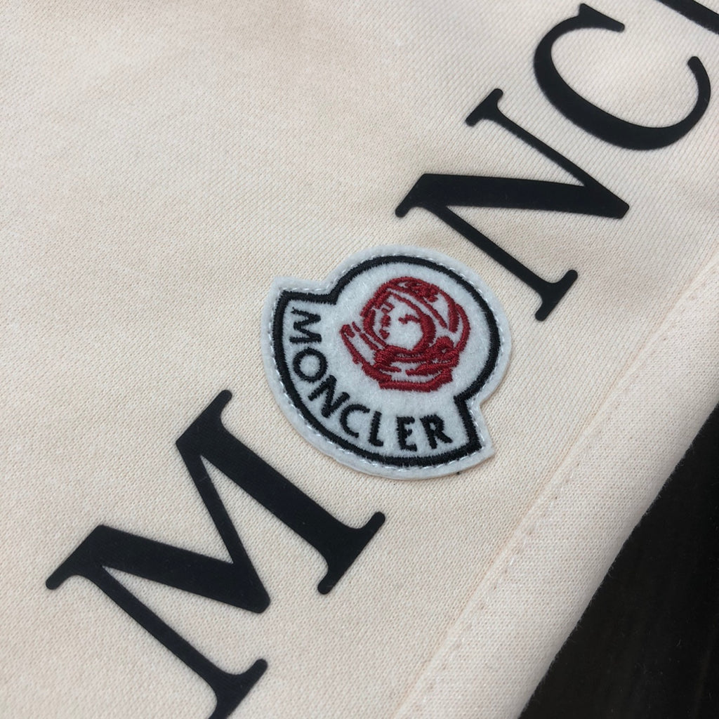 Stone Island shorts detail of Moncler patch logo on cream fabric