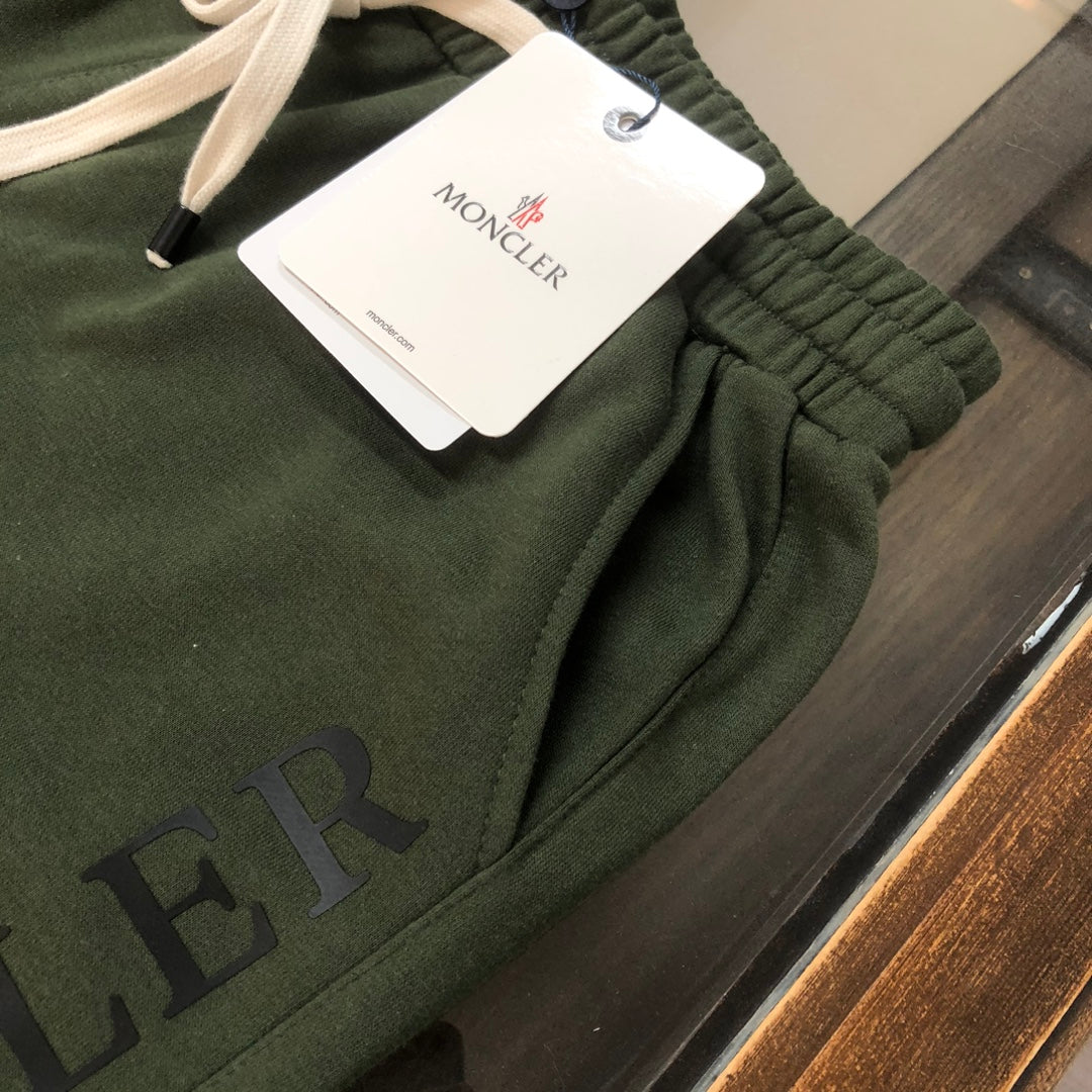 Dark green Moncler shorts with elastic waistband and drawstring, brand tag visible