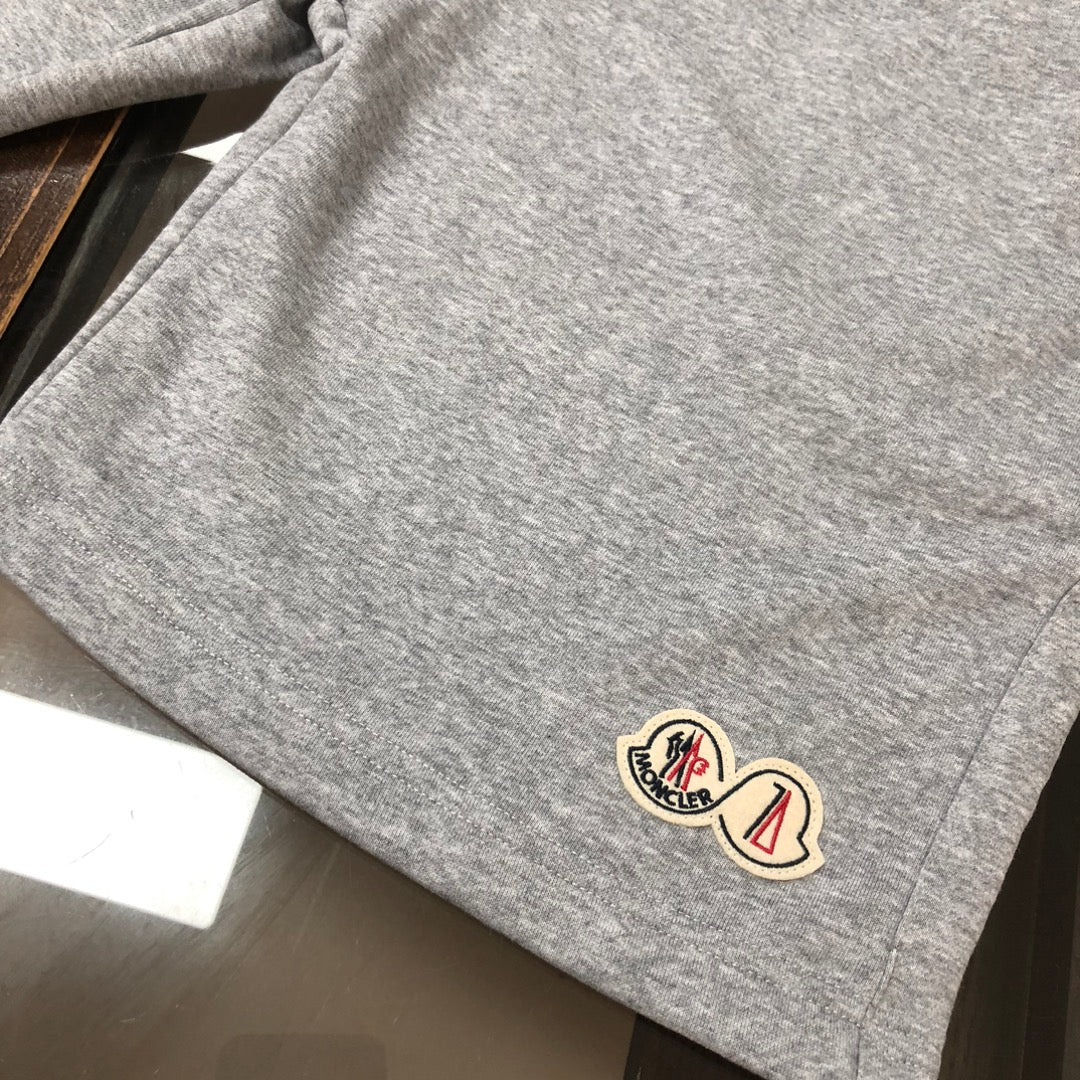 Heather gray drawstring shorts fabric with small logo patch near the hem