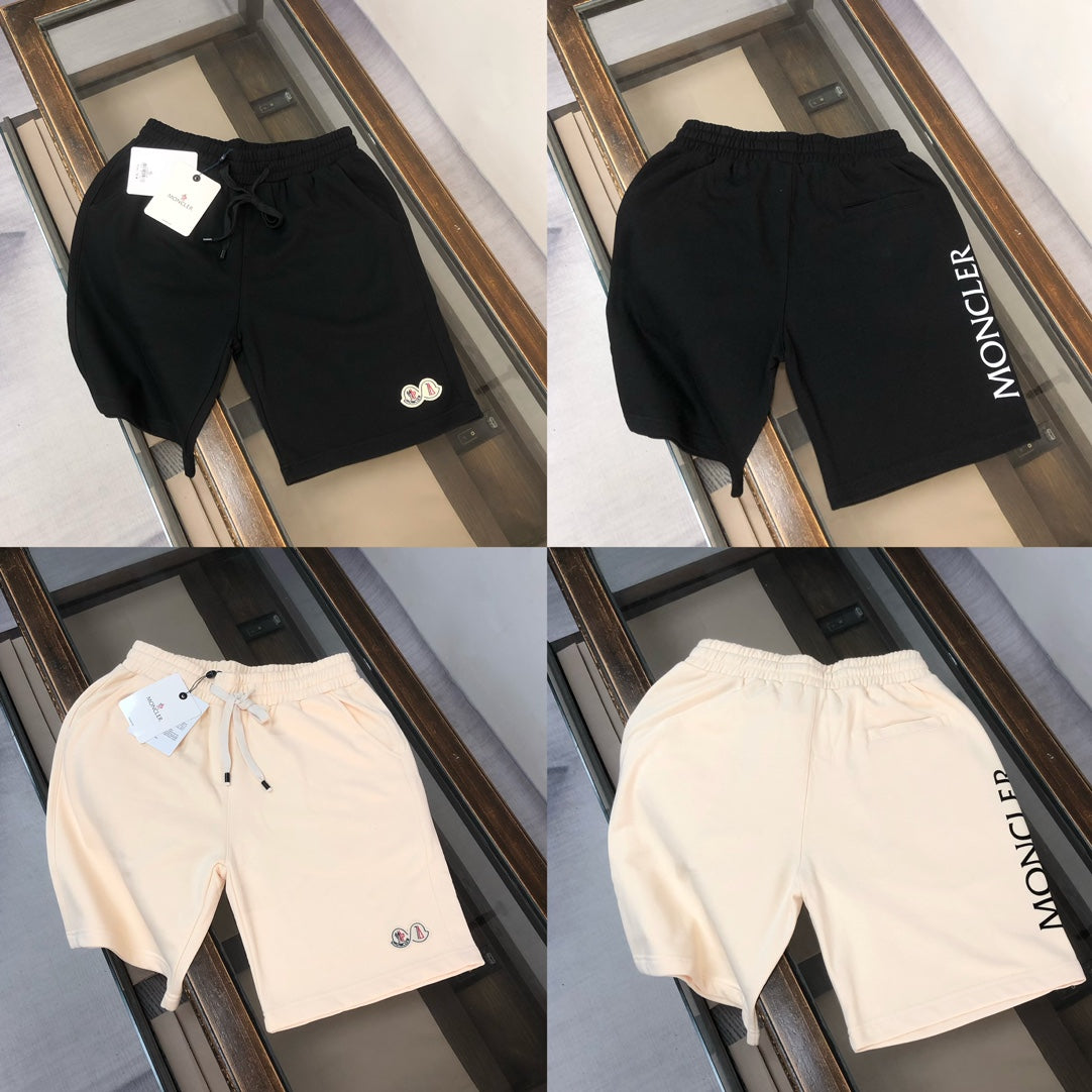 Four drawstring shorts: black and cream, with logo patches and pull ties