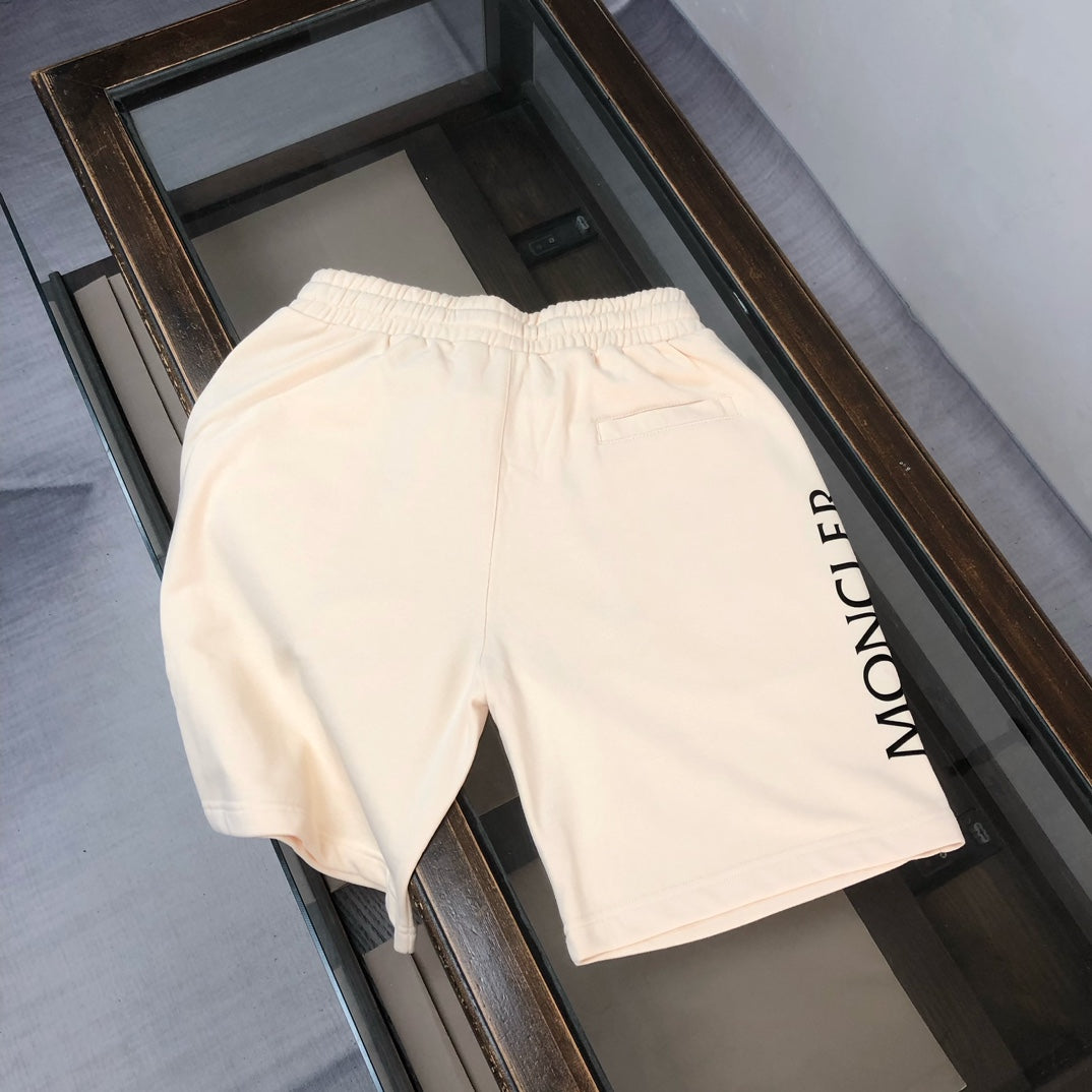 Moncler cream shorts with elastic waistband, drawstring, and vertical logo print