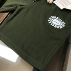Stone Island dark green shorts with circular logo on the front leg