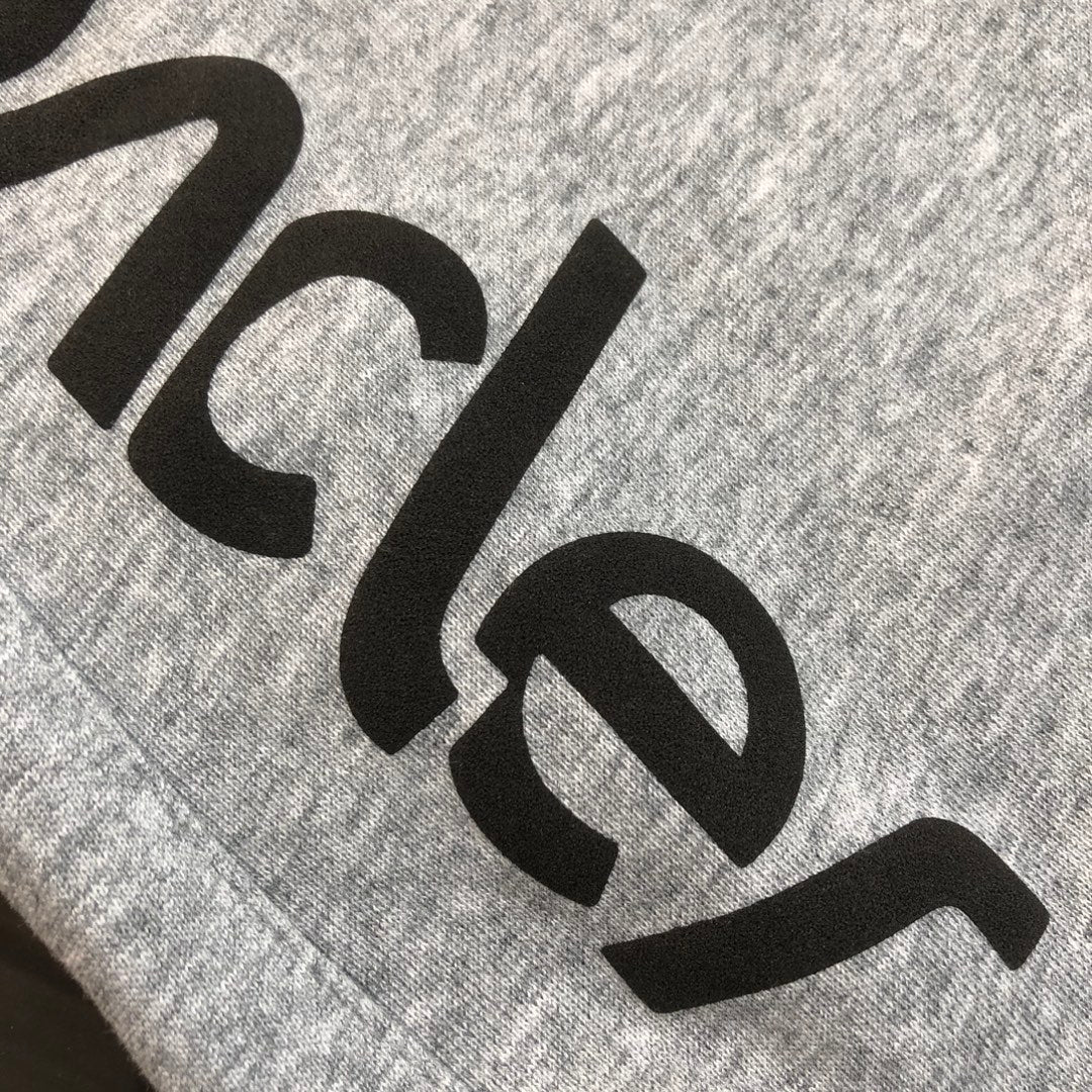 Gray shorts with large black Moncler logo lettering detail