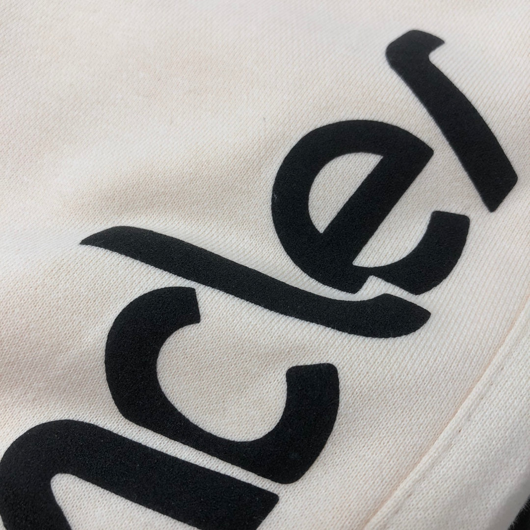 Stone Island cream shorts with close-up black Moncler logo print