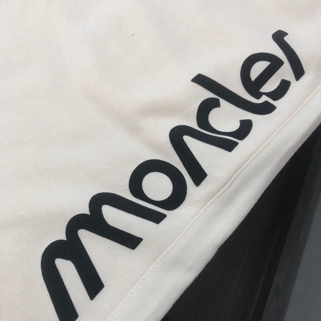 Stone Island cream shorts with close-up black Moncler lettering print