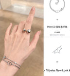 Silver-tone bracelet on wrist with CD charm and small blue bead