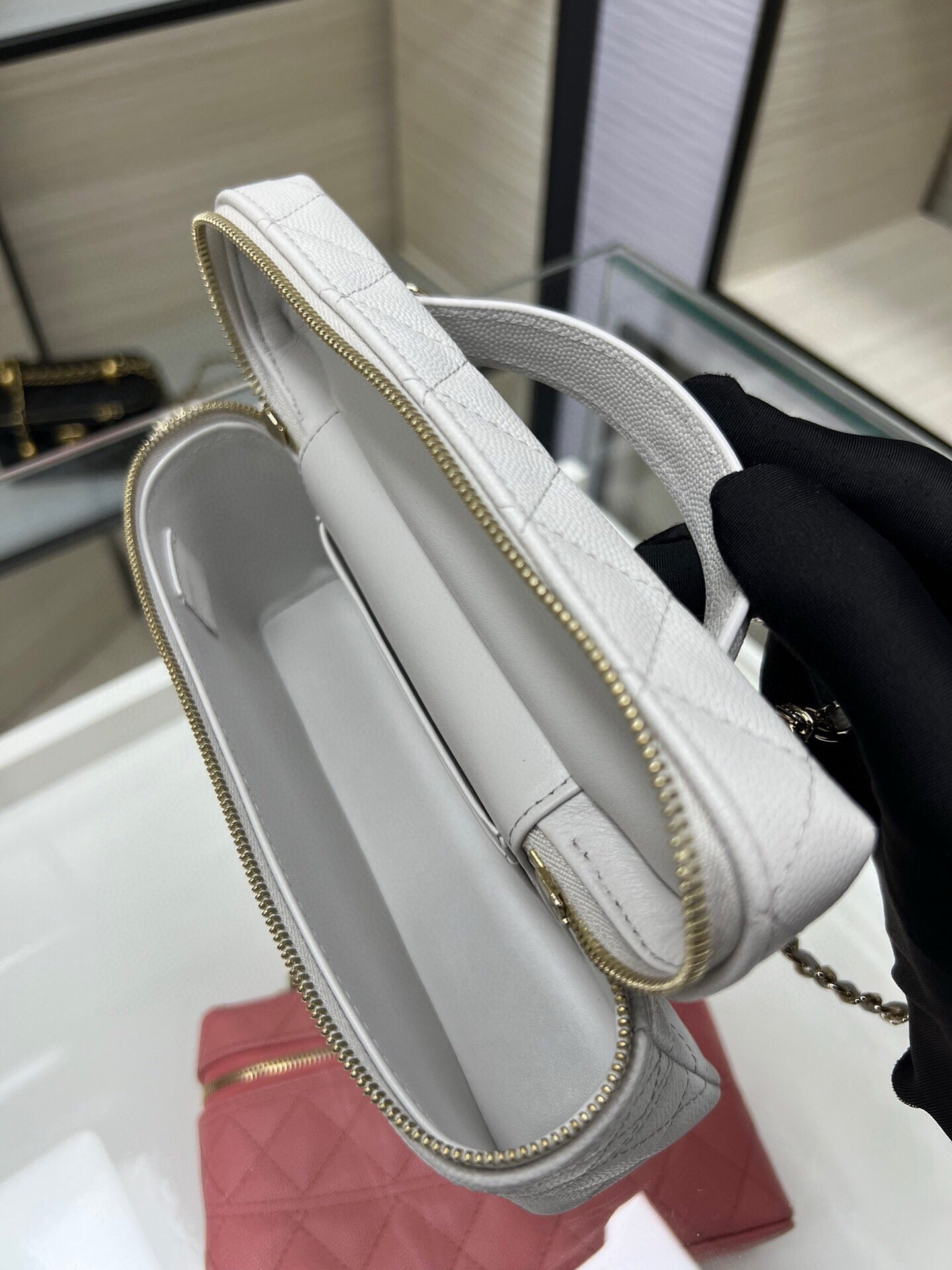 Chanel light gray quilted bag with gold zipper and chain strap, side view