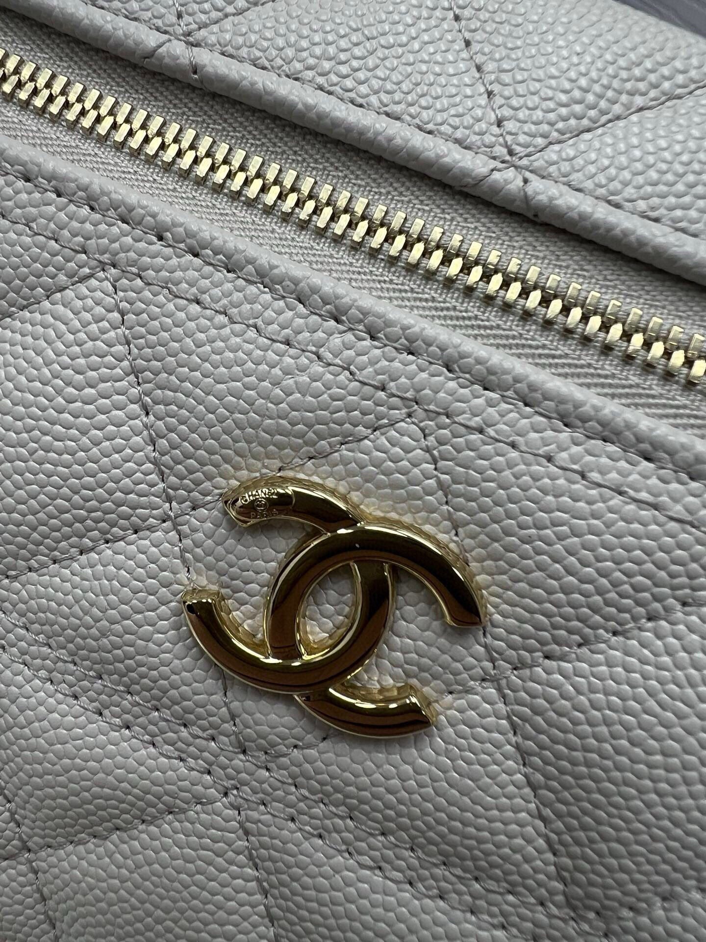 Chanel CC logo on light gray textured leather with gold-tone zipper detail