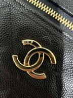Chanel black leather bag close-up with gold CC logo and gold zipper