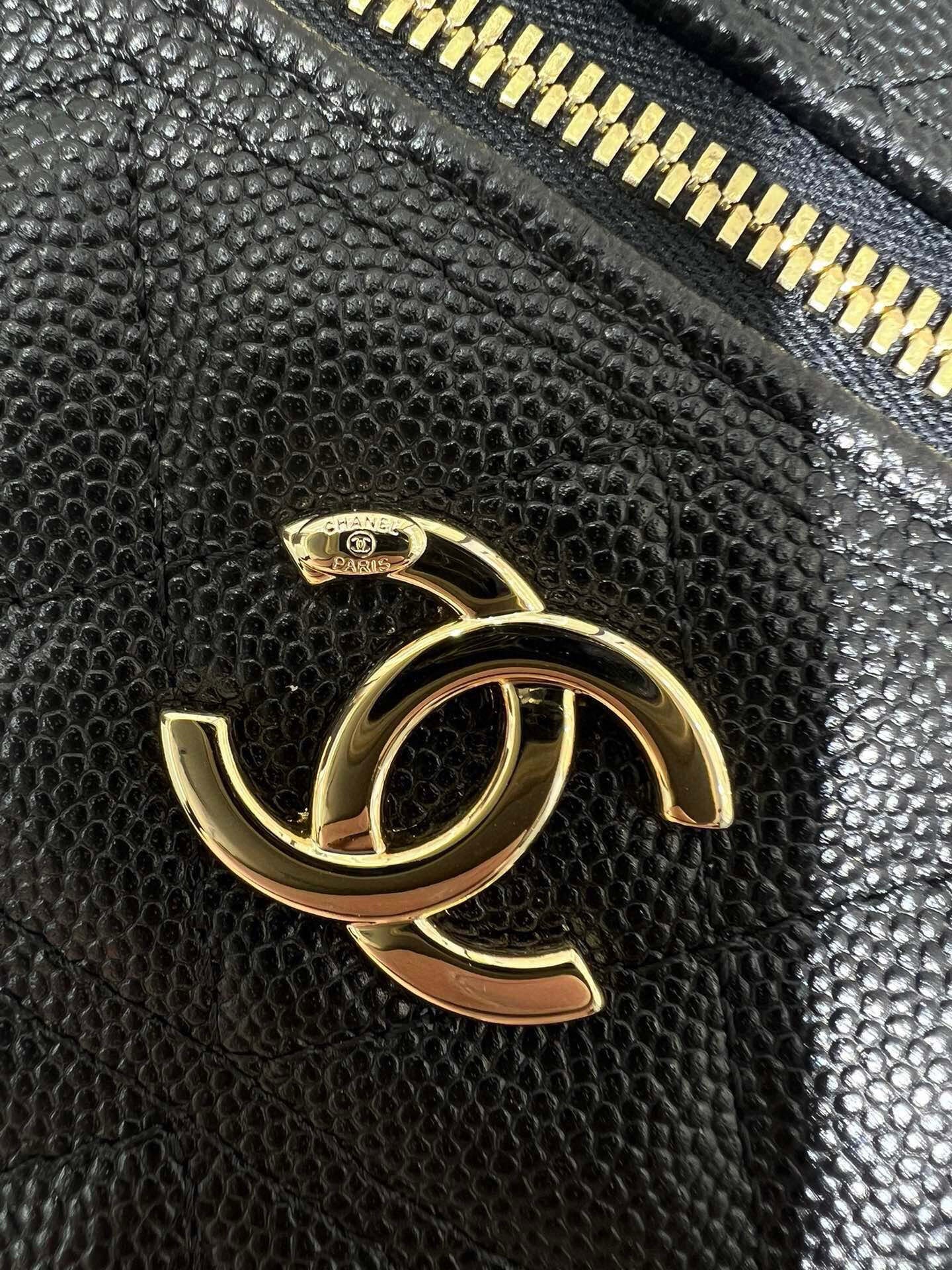 Chanel black leather bag close-up with gold CC logo and gold zipper