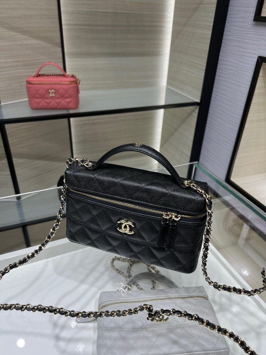 Chanel quilted black mini bag with top handle, chain strap, and gold CC clasp