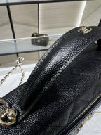 Chanel black textured mini bag with curved gold emblem and chain strap