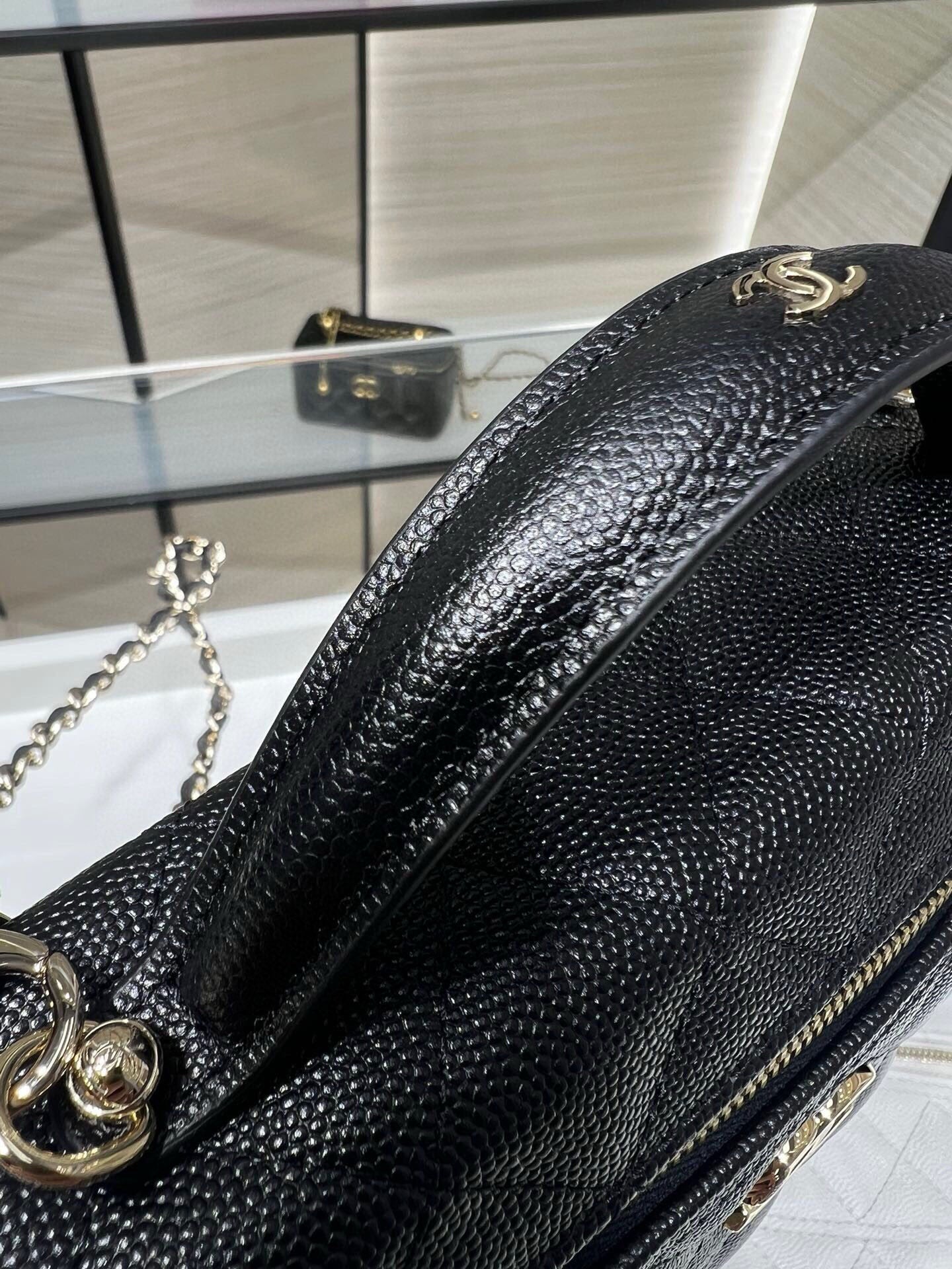 Chanel black textured mini bag with curved gold emblem and chain strap