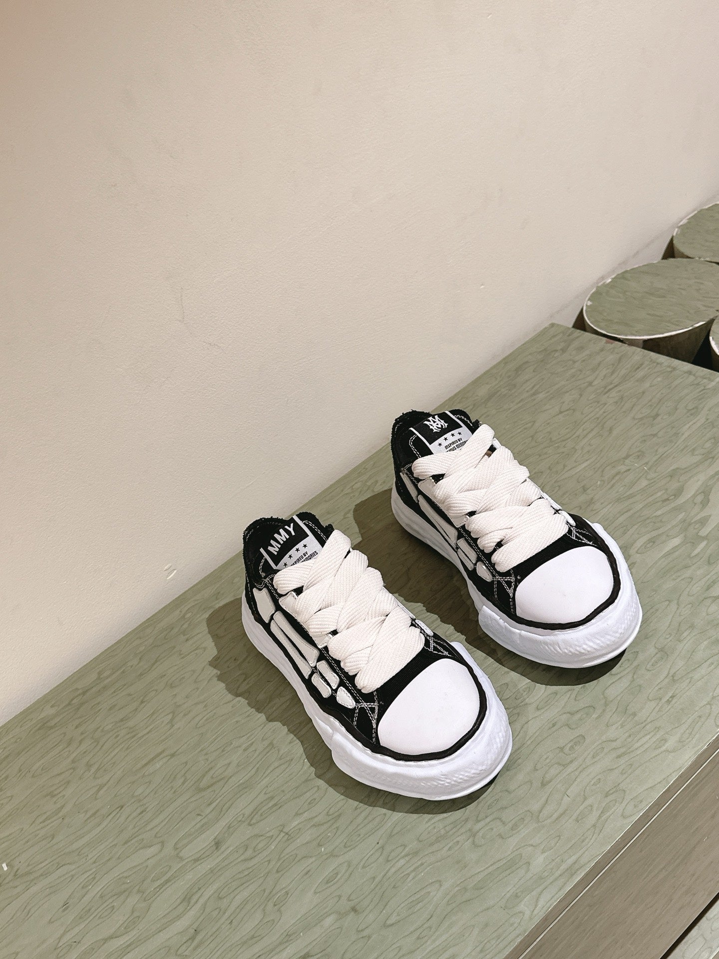 Pair of black and white low-top sneakers on a surface, front view.
