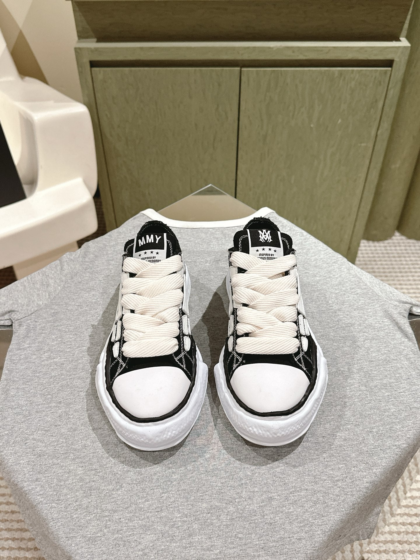 Black and white low-top sneakers with white laces and rubber toe caps.