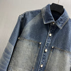 Denim jacket close-up with pointed collar, snap buttons, and chest pocket