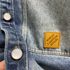 Denim jacket close-up of snap button and Louis Vuitton logo patch on pocket
