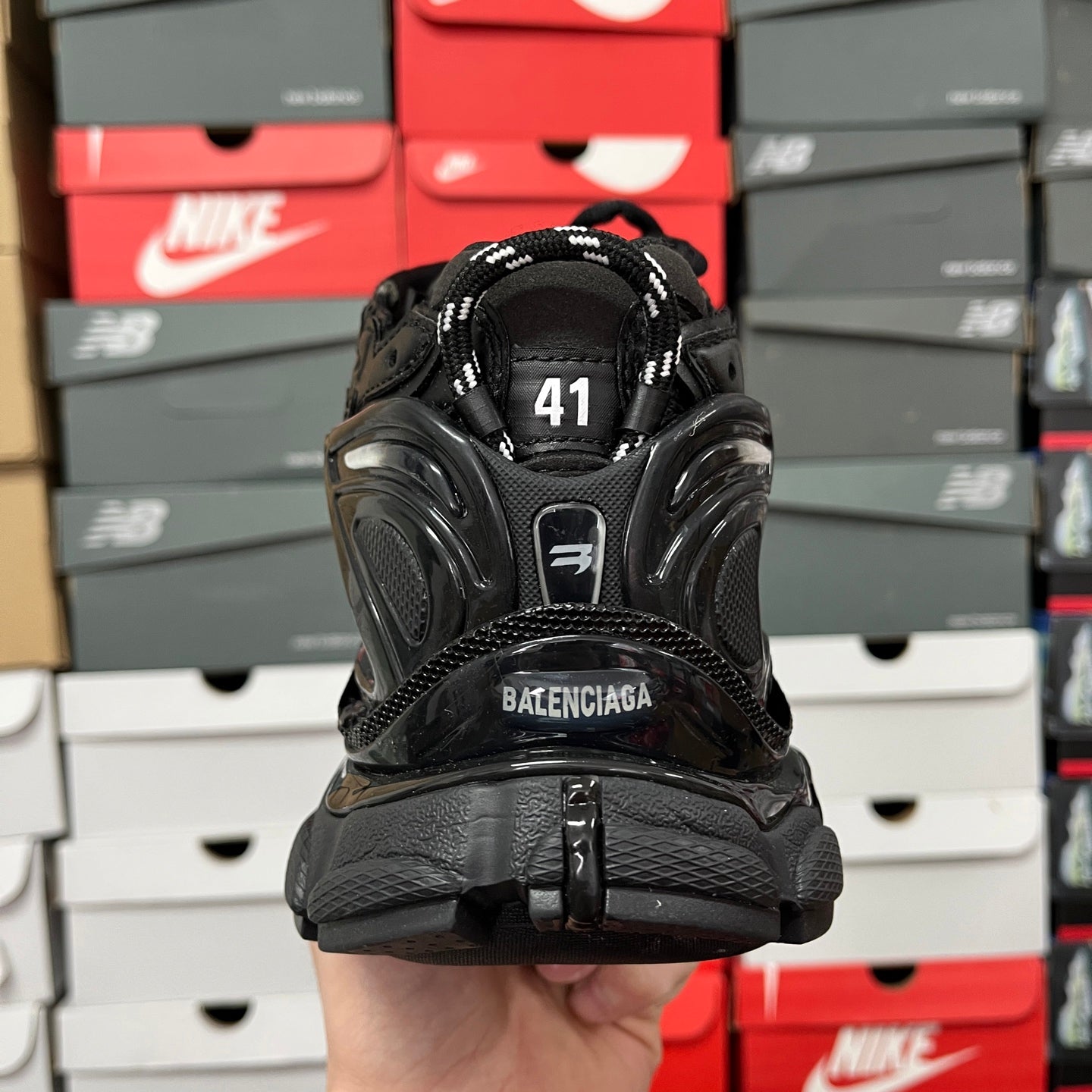 Black Balenciaga running shoe with heel tab showing BALENCIAGA and size 41