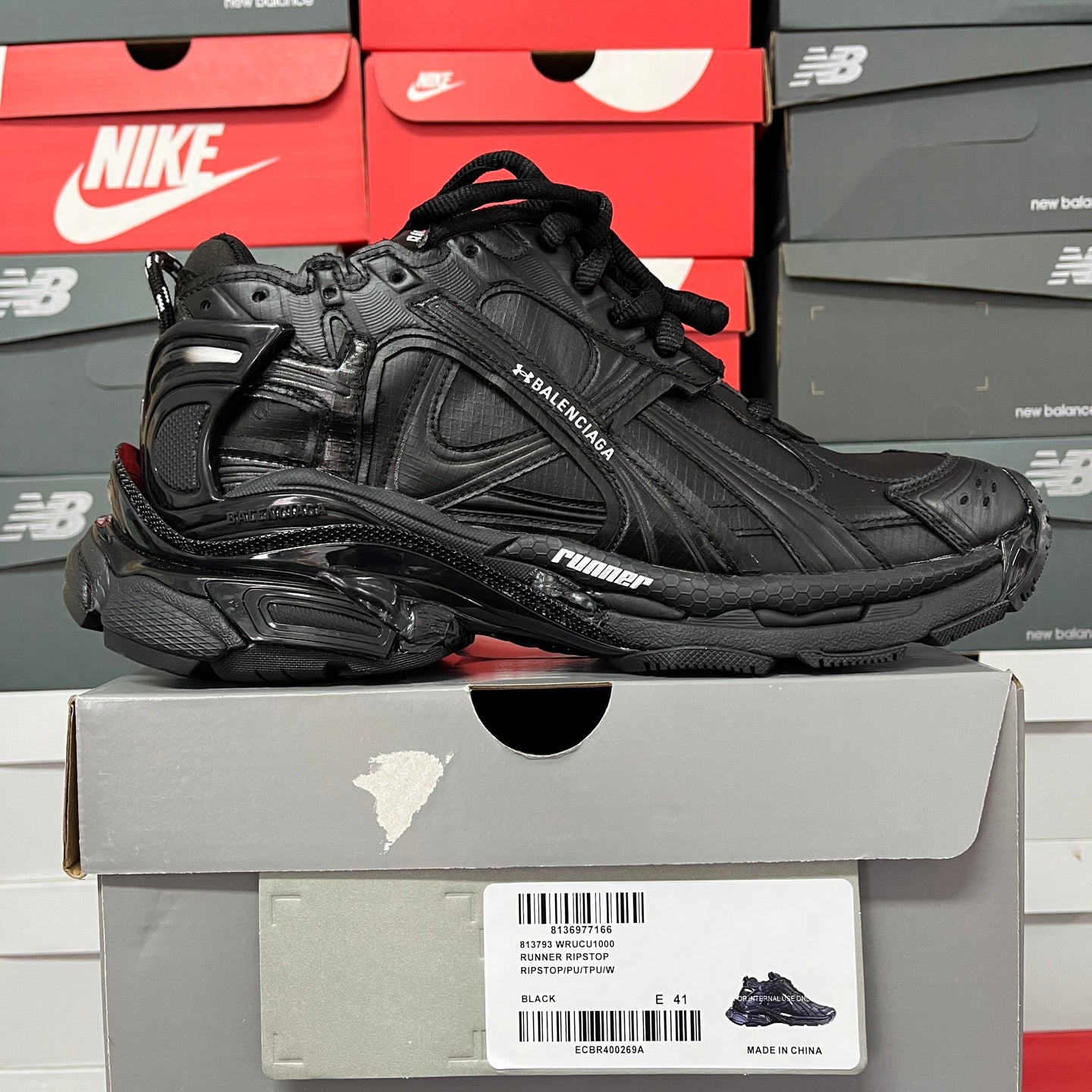 Black Balenciaga running shoe, side view with logo embroidery and molded sole