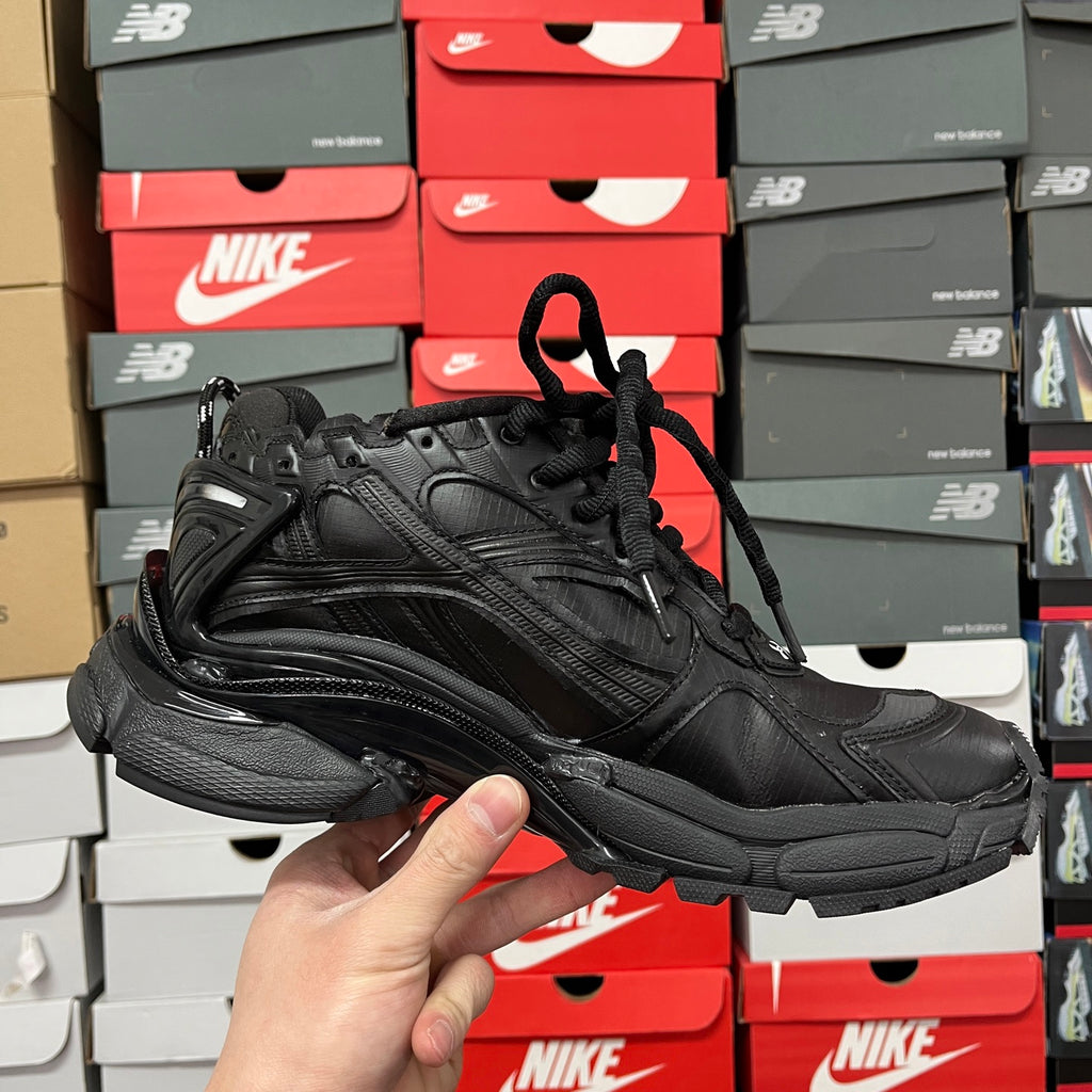 Black Balenciaga running shoe, side angle with lace-up closure and logo detail