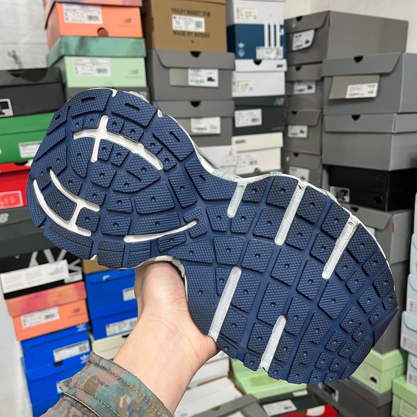 Blue outsole of athletic shoe with grid tread and light stripes for traction.