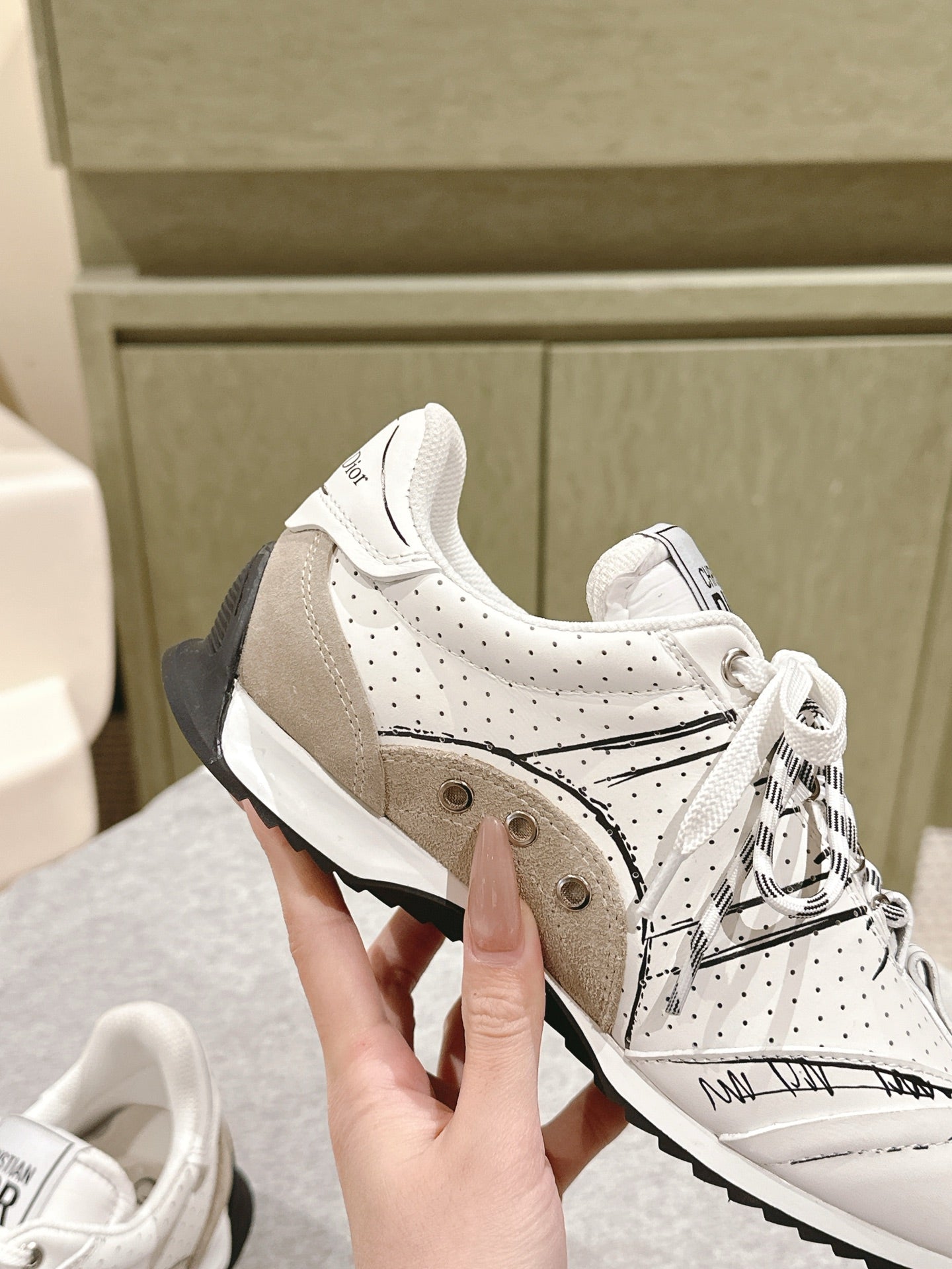 Dior unisex sneakers close-up, white with beige panels and black heel detail