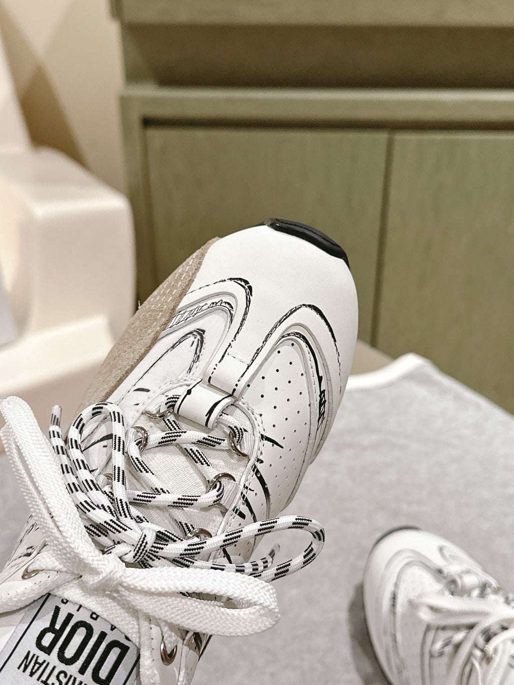 Dior unisex sneakers detail, white toe cap with patterned laces and Dior logo