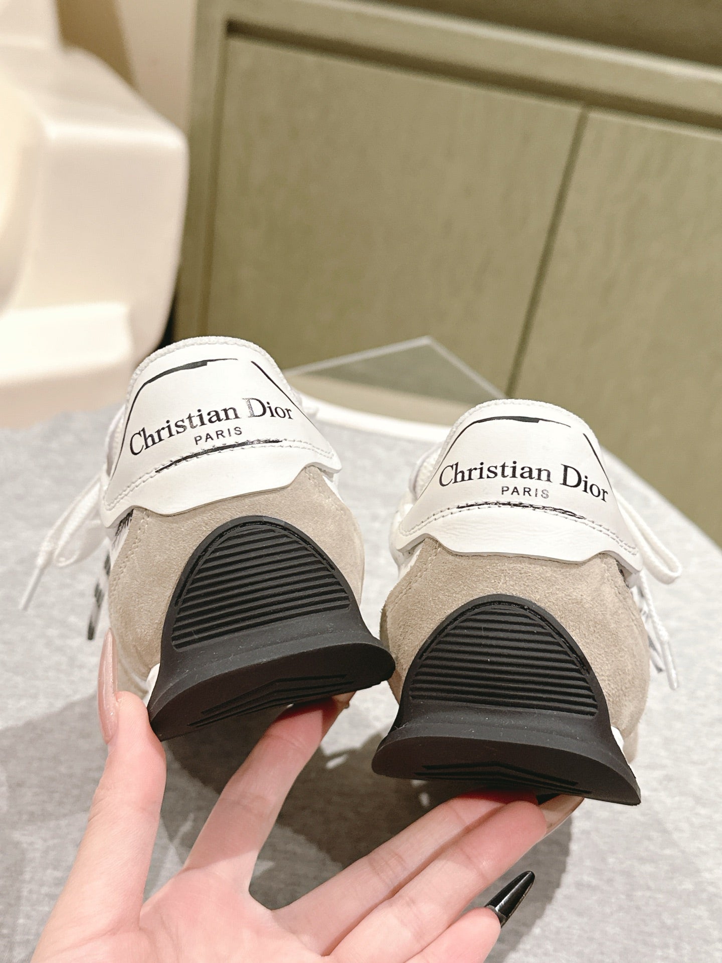 Dior unisex sneakers, rear view of treaded black soles with branded heel tabs