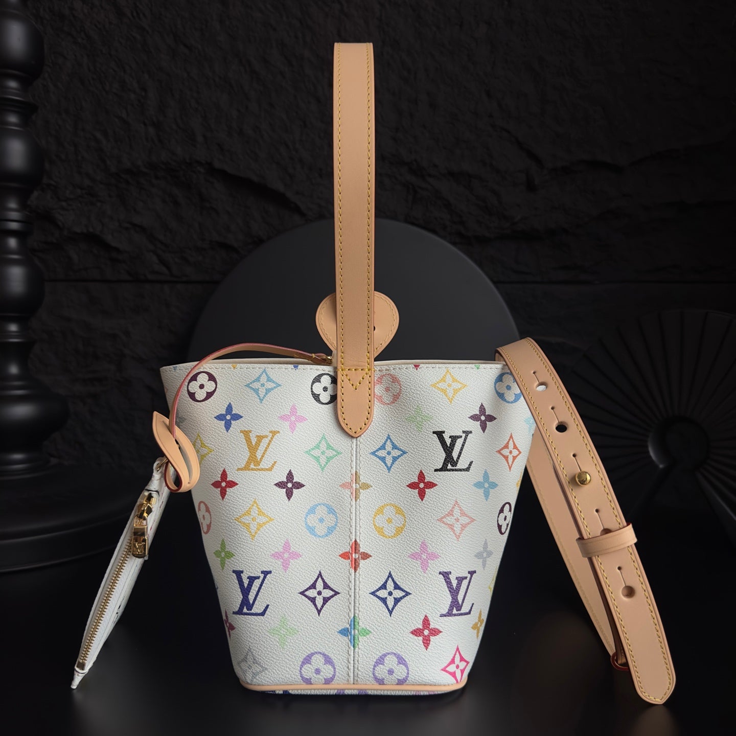 Louis Vuitton monogram bucket bag with tan shoulder strap, zipper pocket, colorful logo print