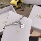 Dior necklace with charm tag and small logo pendant on a white card