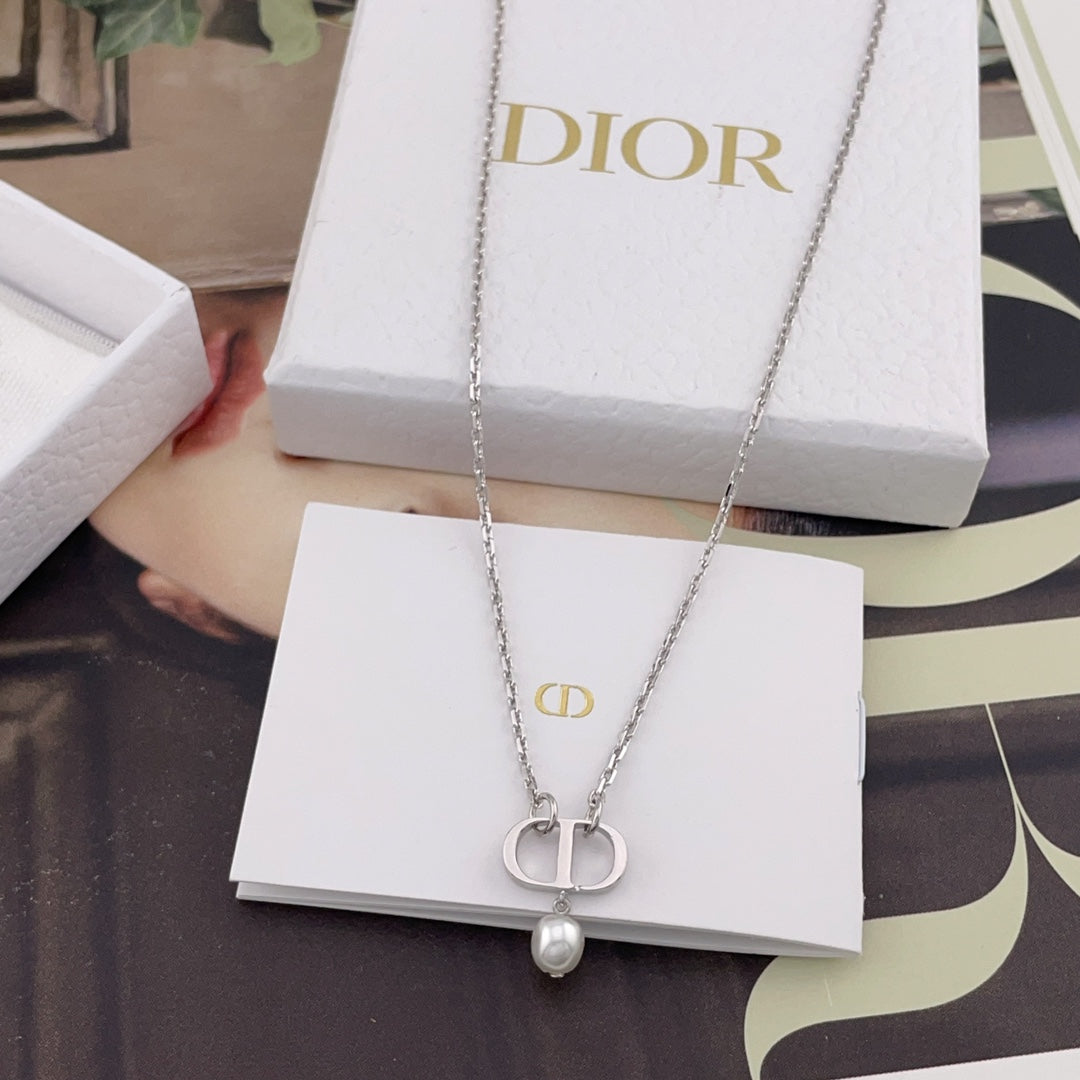 Dior necklace with interlocking pendant and pearl bead on a white gift card