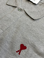 Gray polo shirt button placket with embroidered red heart A logo