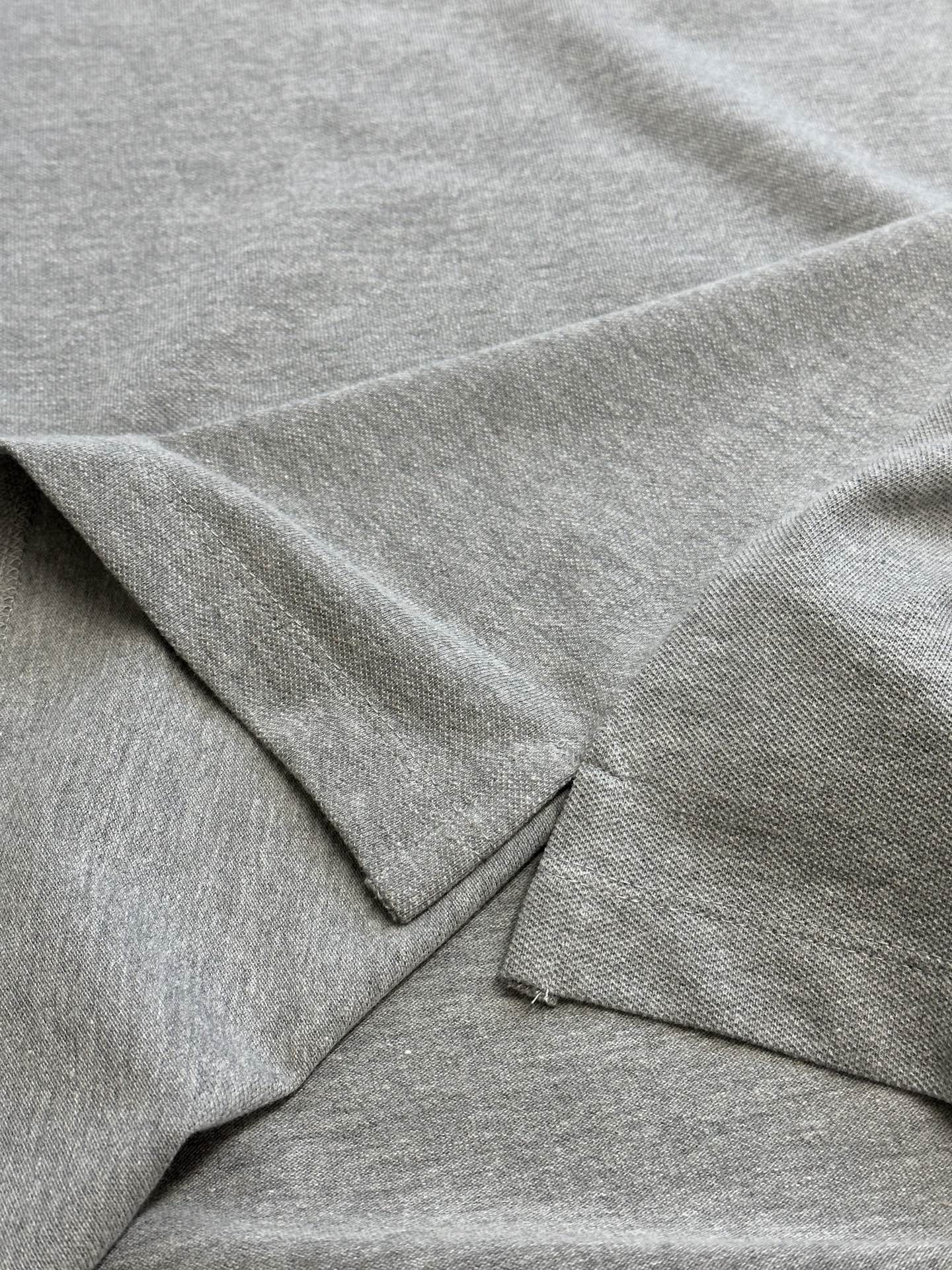 Light gray polo shirt fabric and seam detail with short sleeve edge