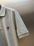 Gray polo shirt with short sleeve and red heart A emblem on the chest side