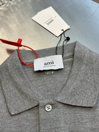 Gray polo shirt neckline with pointed collar, button closure, and attached clothing tags