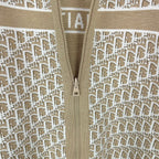 Beige knit jacket close-up of center zipper and white monogram pattern