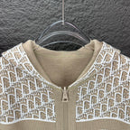 Beige hooded zip jacket close-up with white monogram knit and zipper pull