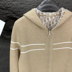 Beige zip hoodie close-up with hood, center zipper, and white stripe accents