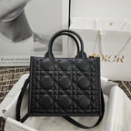 Black quilted handbag with top handle and shoulder strap, front view